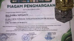 Piagam penghargaan dan medali prestasi Ira Zahra Novianty, siswi SMK Negeri 4 Surabaya, sebagai Juara 1 Seni Tunggal Tangan Kosong Putri Remaja pada Kejuaraan Pencak Silat City of Heroes Championship 2026 Piala Kementerian Kebudayaan Republik Indonesia.