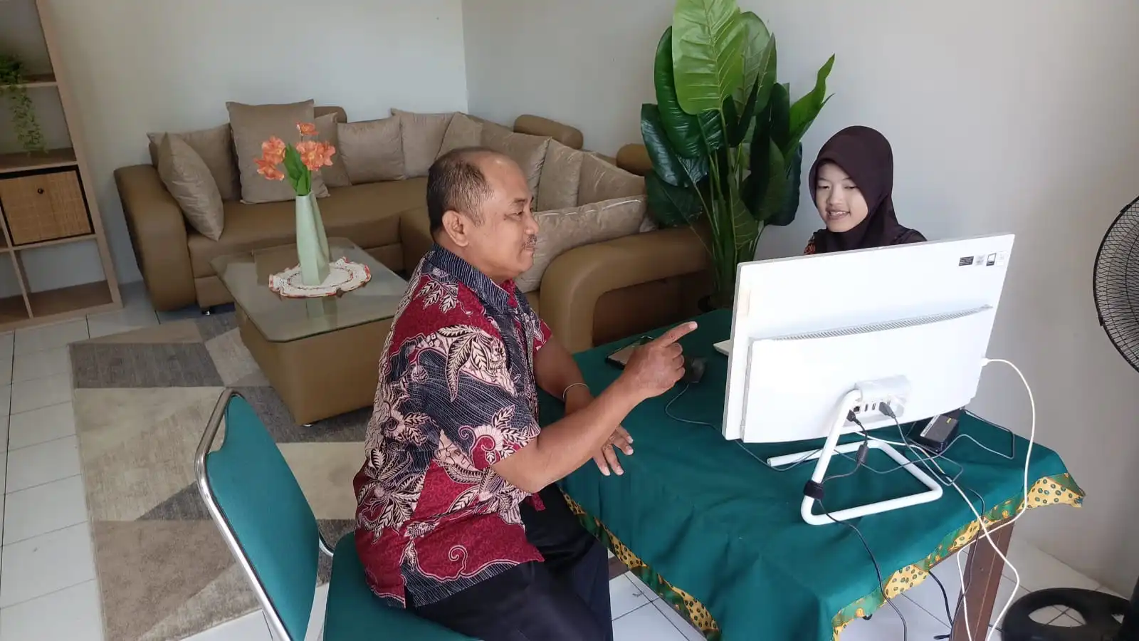 Four Tax Consulting SMK Negeri 4 Surabaya menampilkan kegiatan konsultasi perpajakan antara siswa dan pendamping menggunakan komputer.