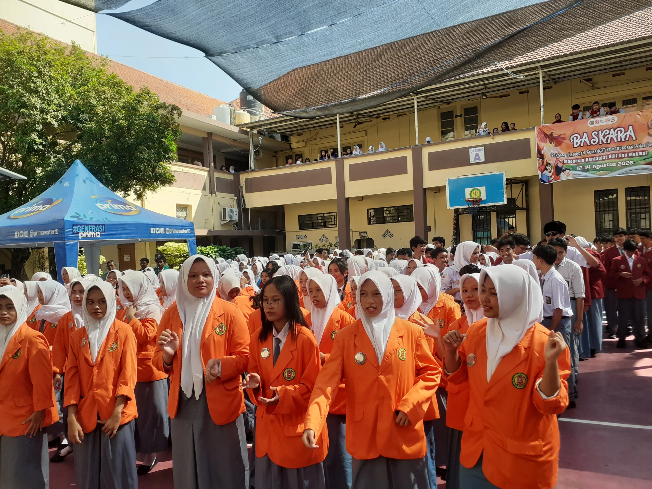 Siswa SMKN 4 Surabaya berjaket almamater sesuai jurusan mereka masing-masing mengikuti kegiatan sekolah di lapangan.